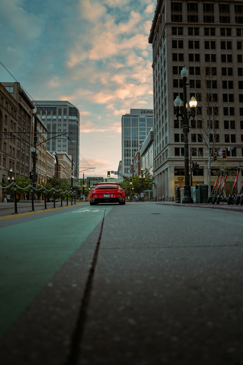 a red truck driving down a street next to tall buildings
