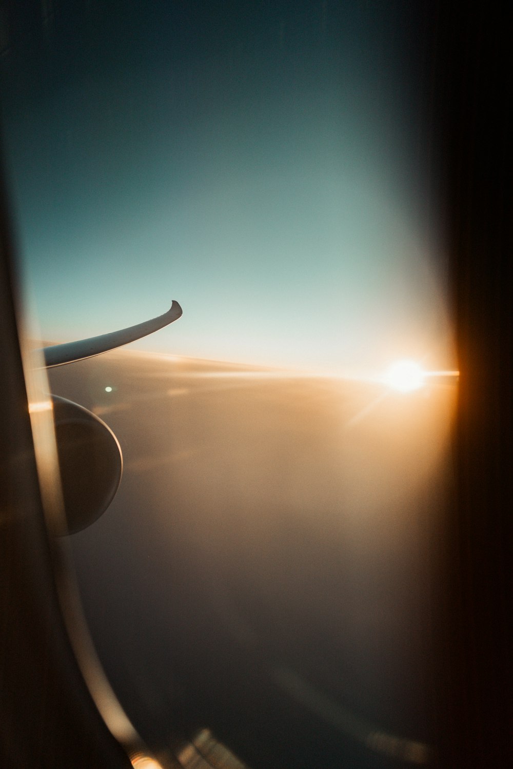 a view of the wing of an airplane as the sun sets