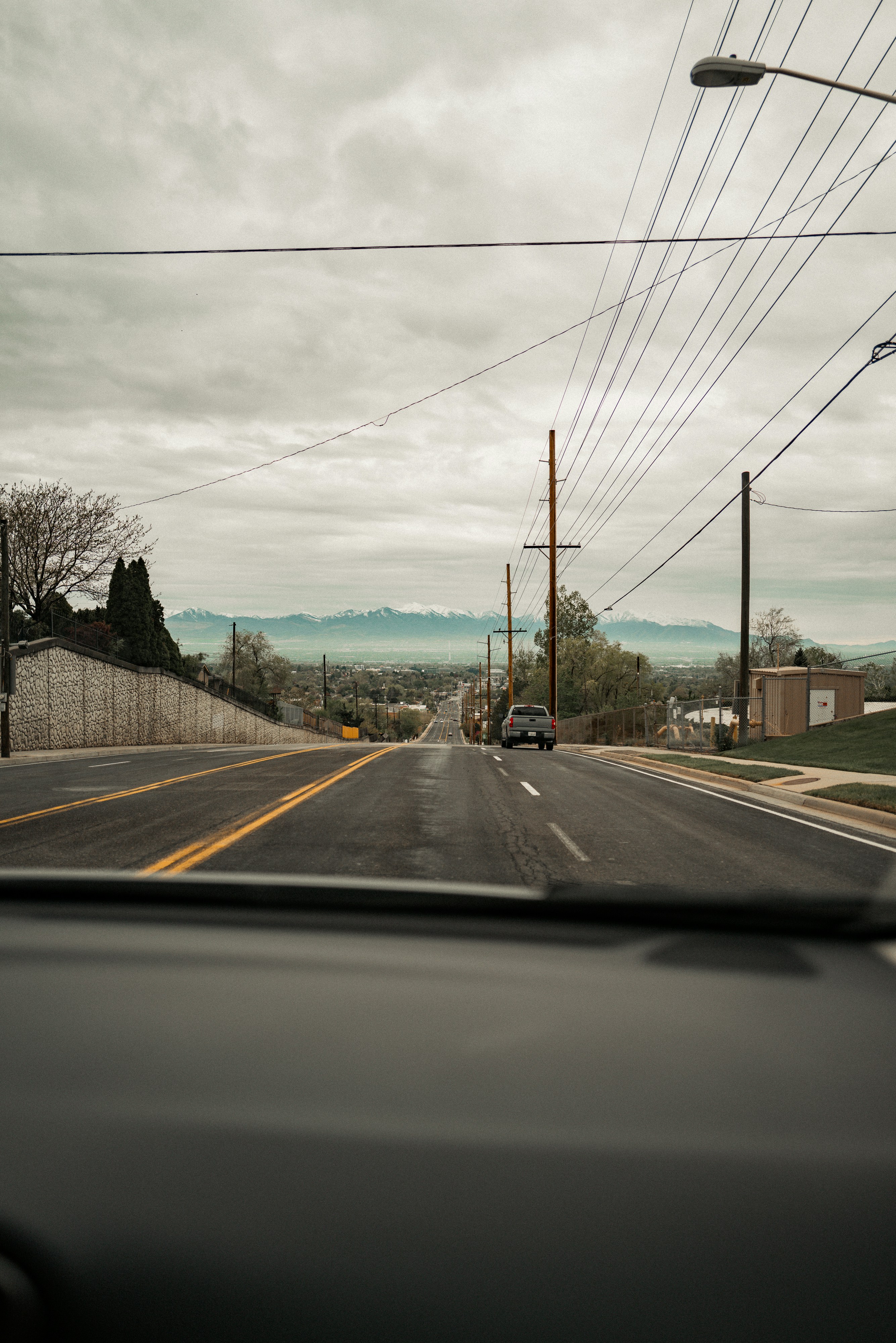 ein Auto, das eine Straße neben Stromleitungen entlangfährt