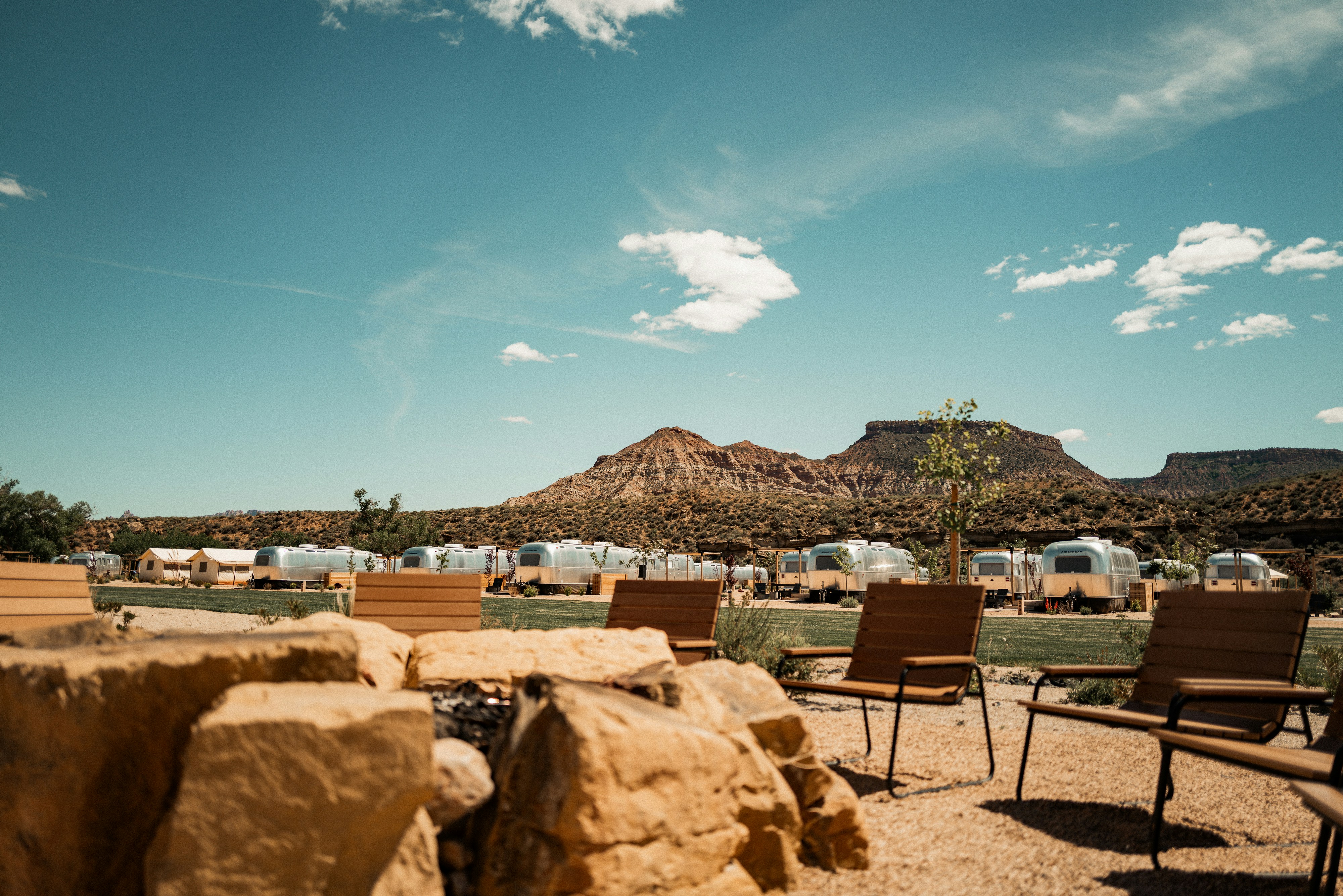 a group of chairs sitting on top of a dirt field