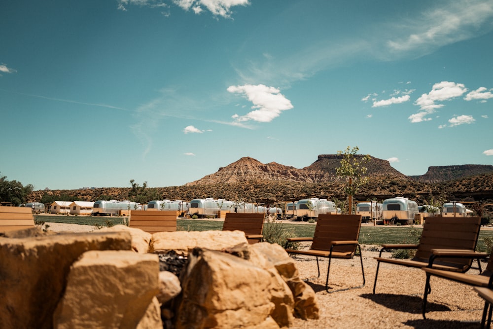 a group of chairs sitting on top of a dirt field