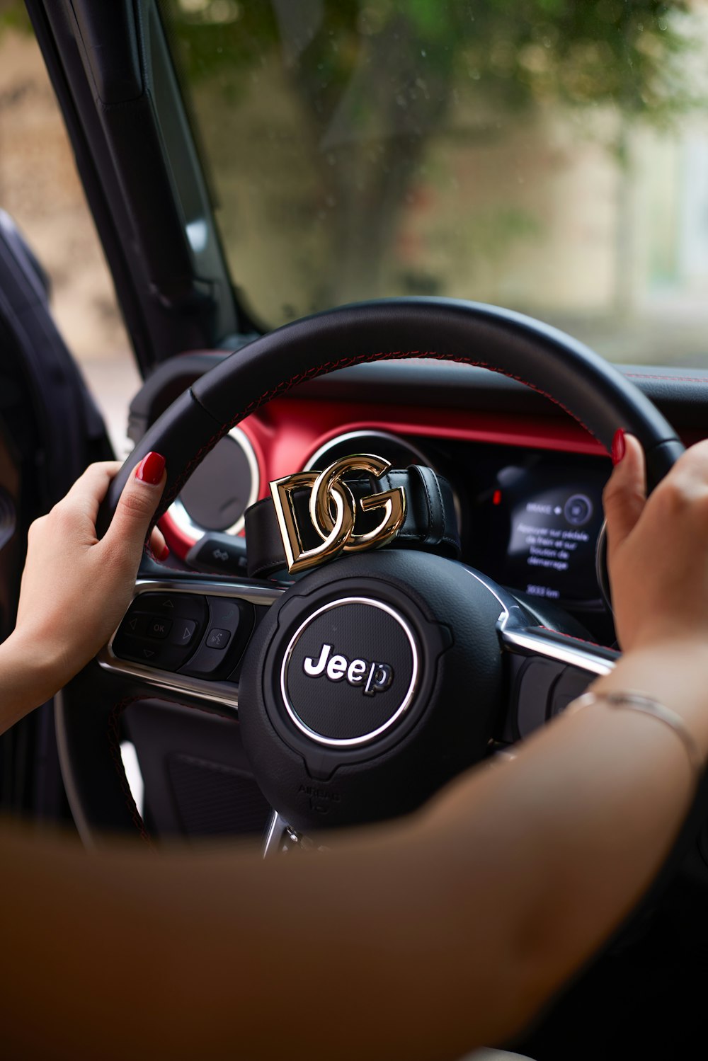 a woman driving a car with a steering wheel