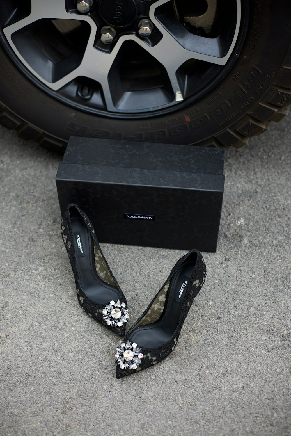 a pair of black high heeled shoes next to a black box