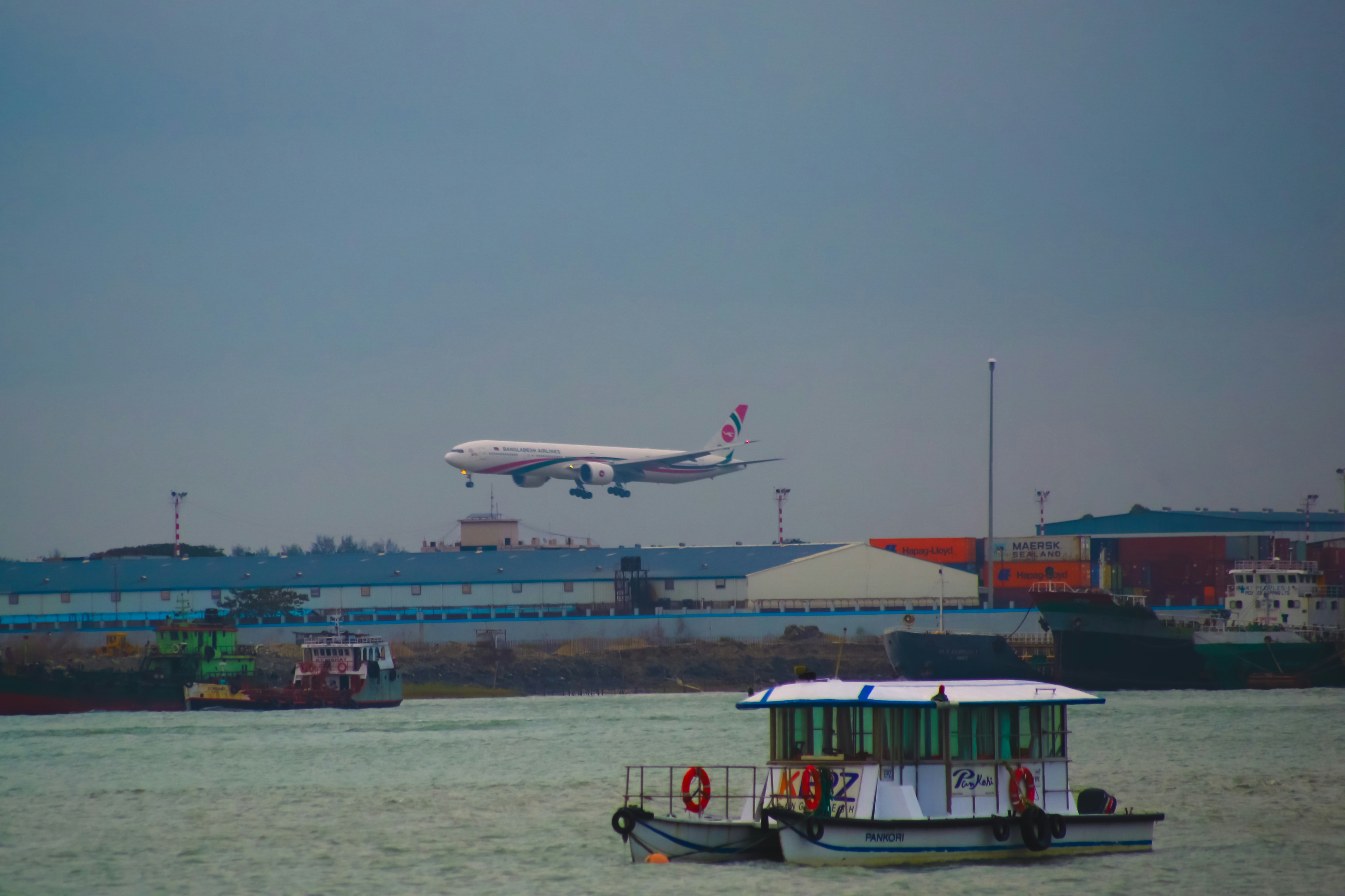 a large jetliner flying over a body of water