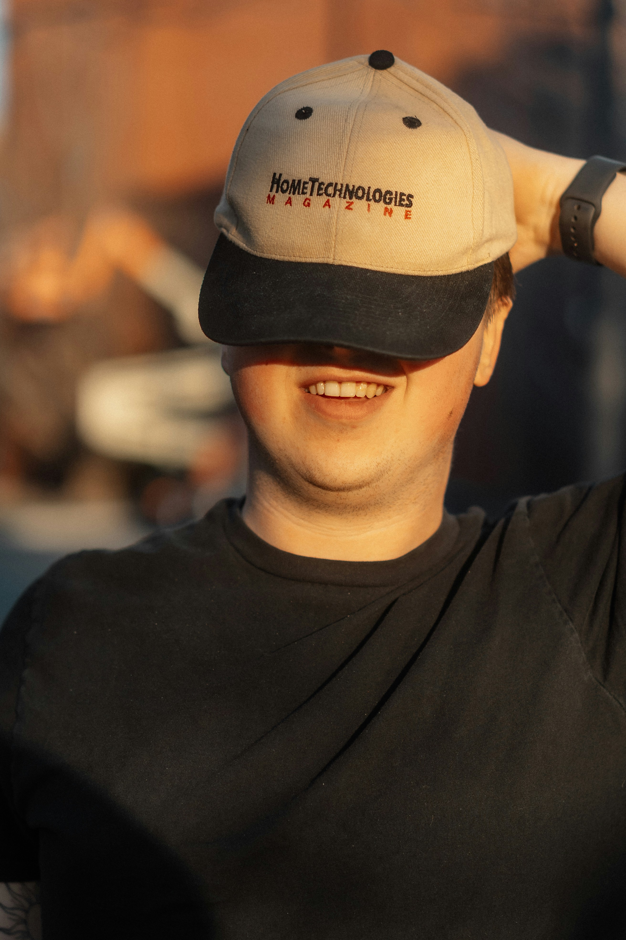a smiling man wearing a hat with the word home technologies on it