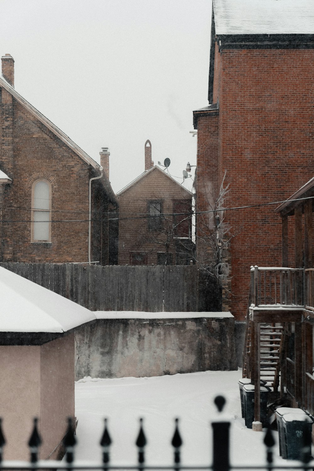 a snow covered yard with a clock tower in the background