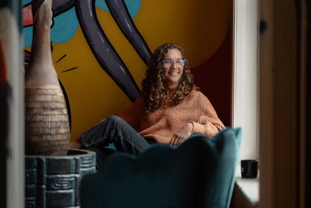 a woman sitting in a chair in front of a painting