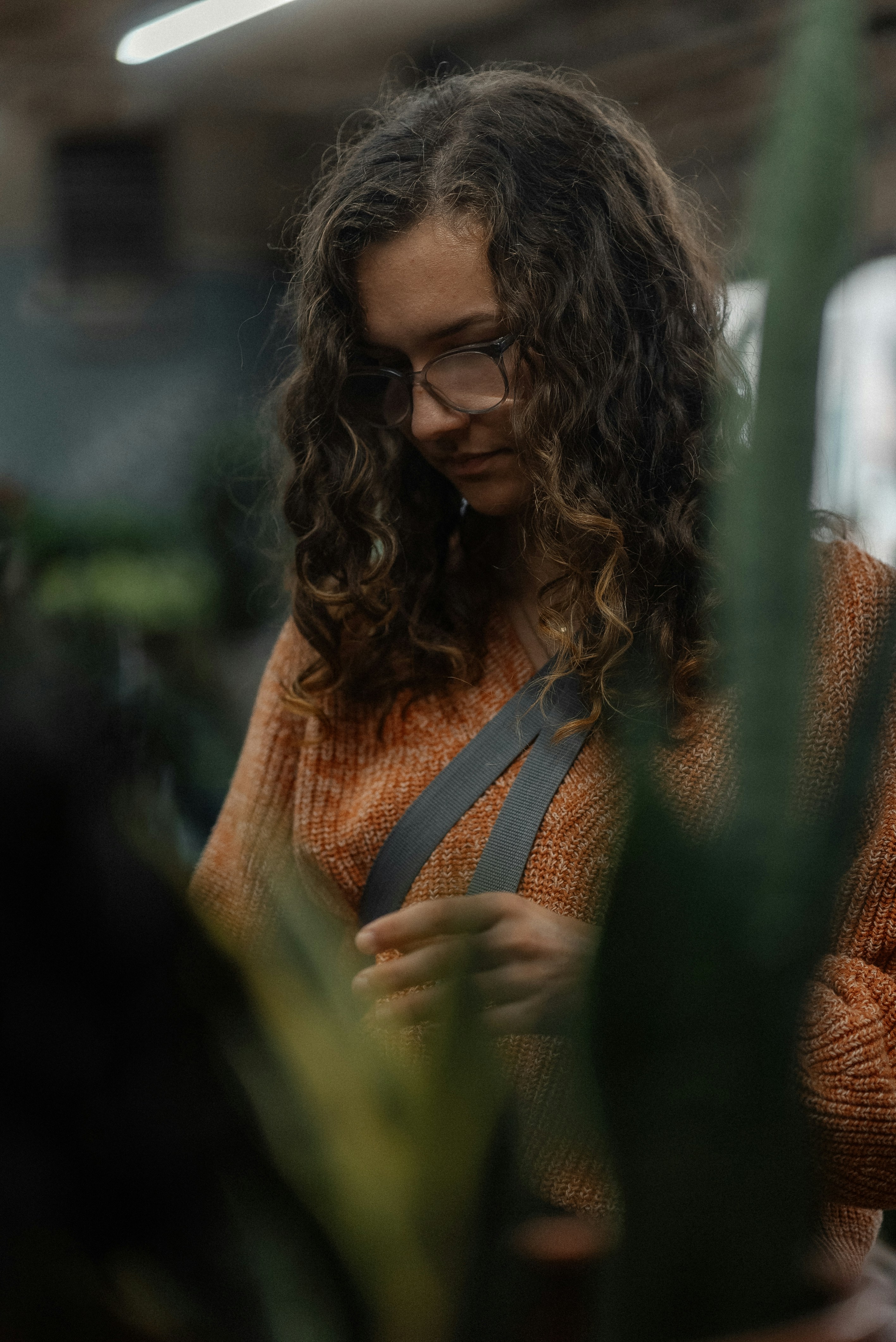 a woman wearing glasses looking at her cell phone