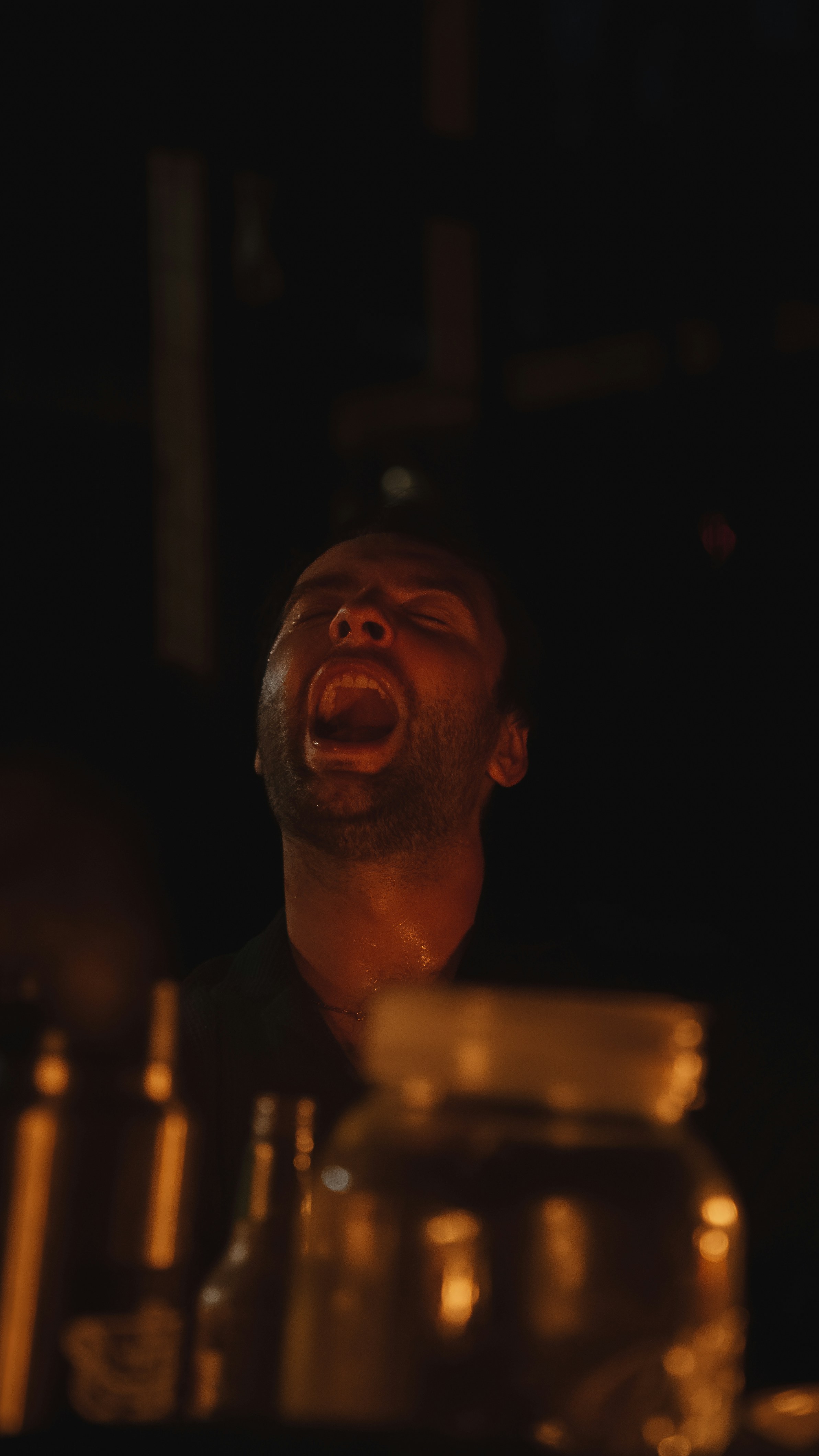 a man with his mouth open in the dark