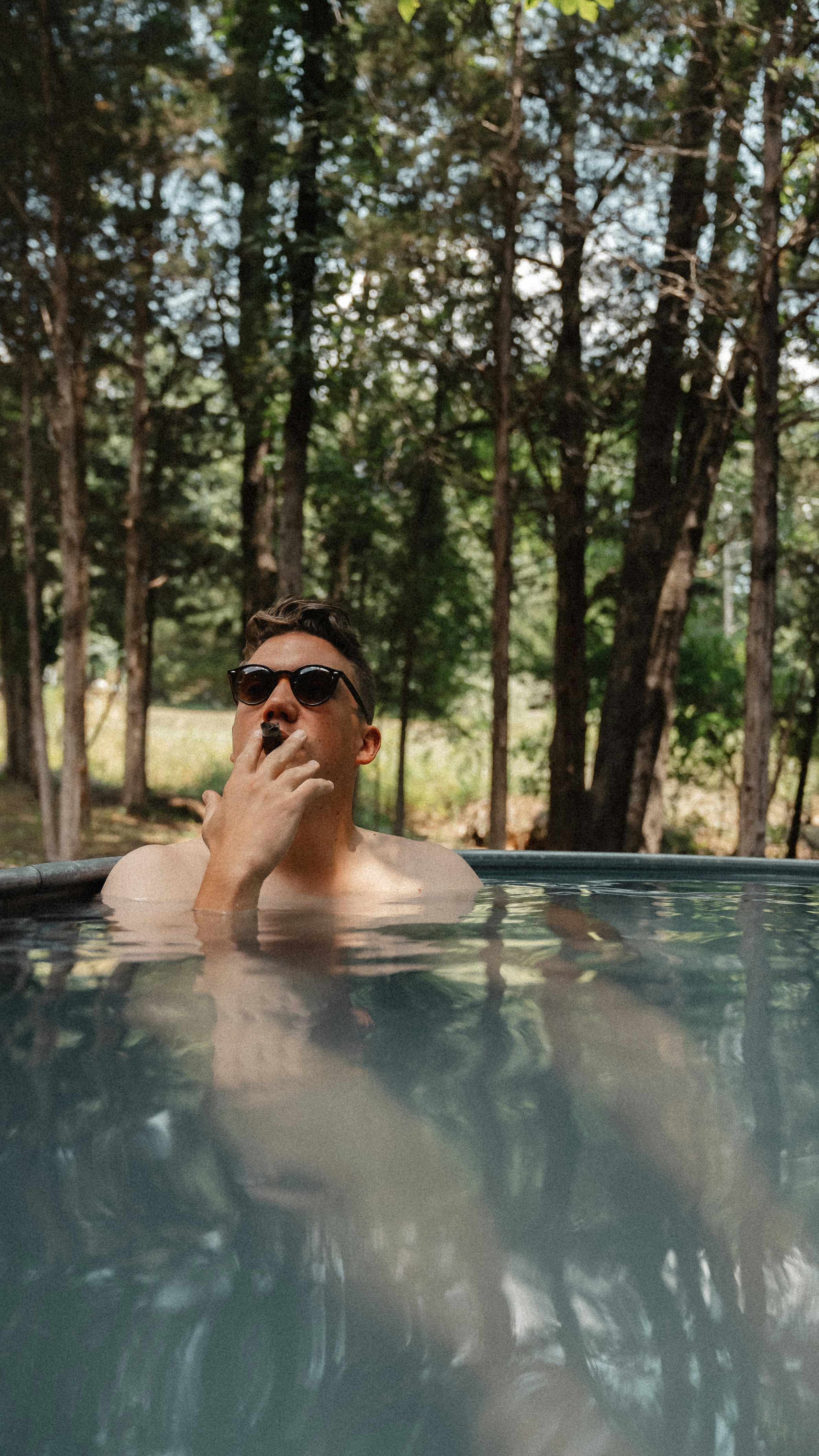 a man in a swimming pool talking on a cell phone