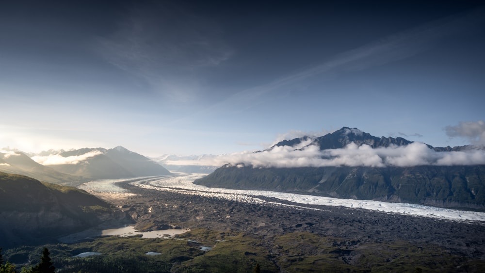 a river running through a valley surrounded by mountains