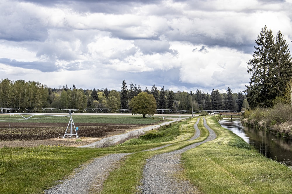 a dirt road next to a body of water