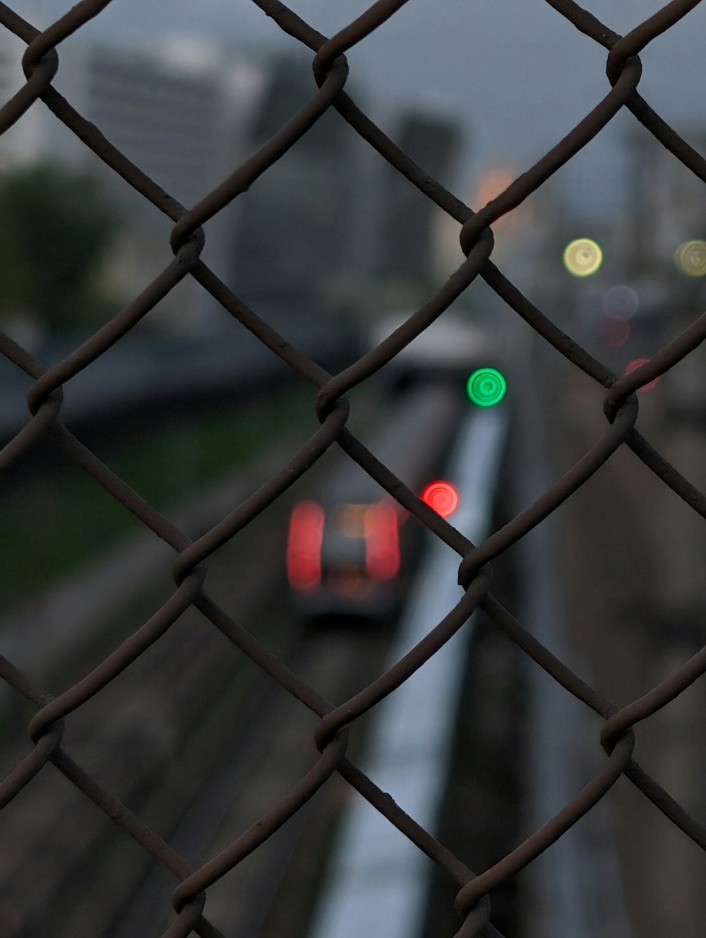 a view of a train from behind a chain link fence