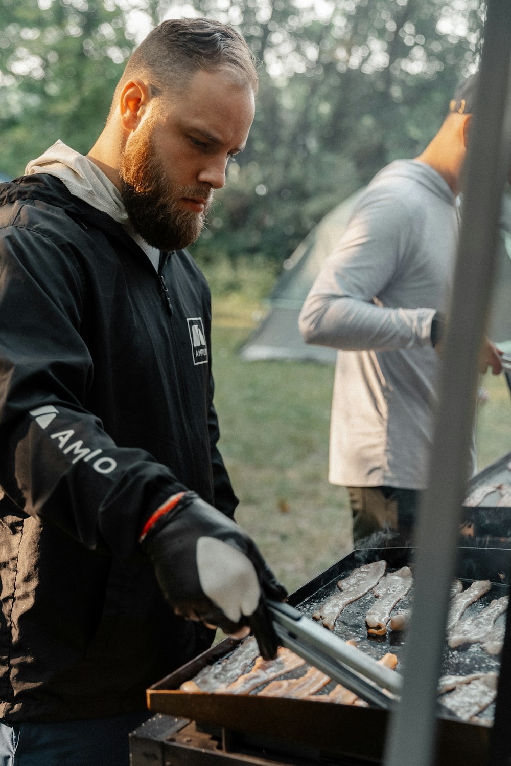 a man grilling food on a grill outside