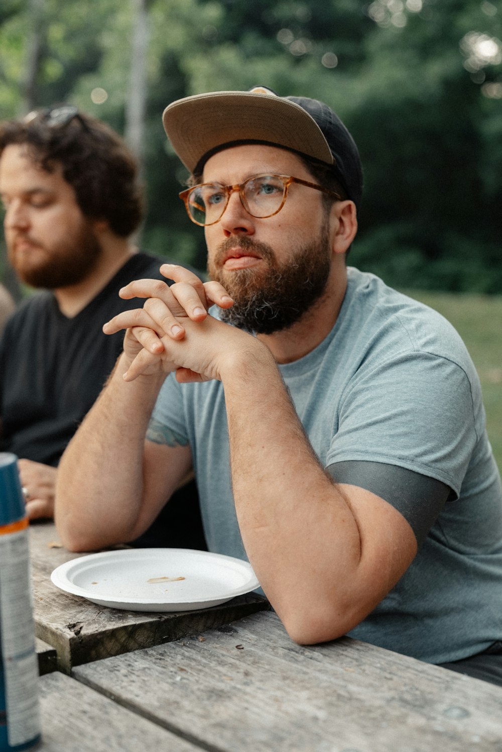a man sitting at a picnic table with a plate of food