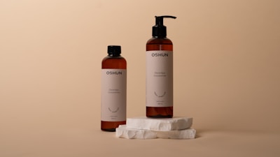 two bottles of shampoo sitting on top of a white piece of paper