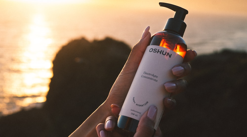 a person holding a bottle of sun tanning lotion