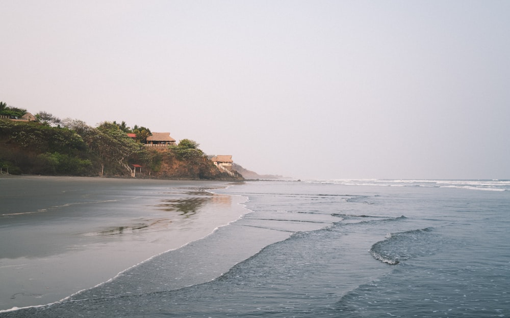 a sandy beach with waves coming in to shore