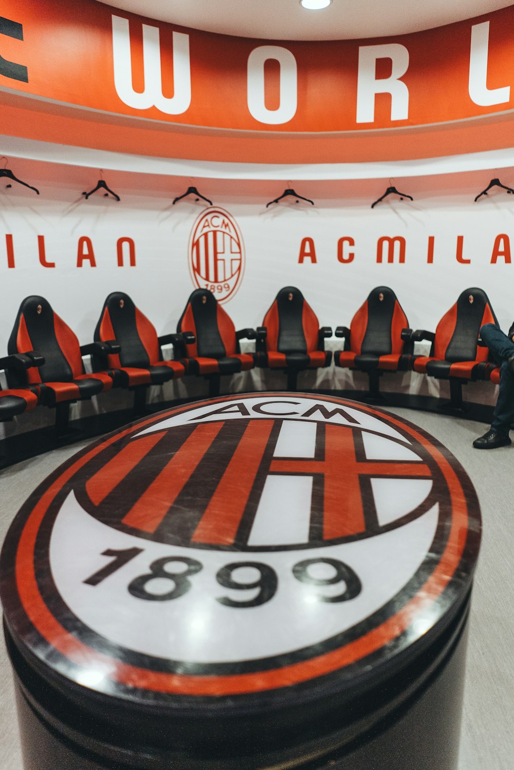 a man standing in front of a bench in a soccer stadium