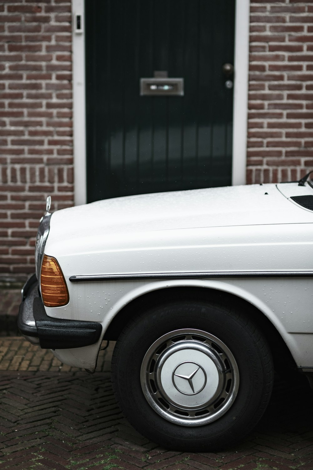 a white car parked in front of a brick building