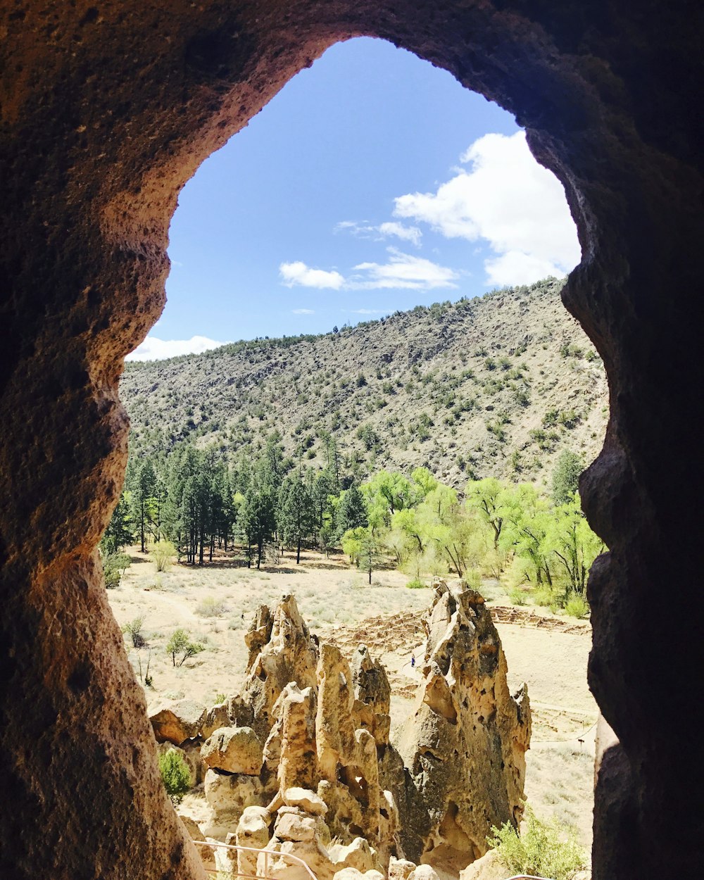 a view of a rocky landscape through a hole in a rock wall