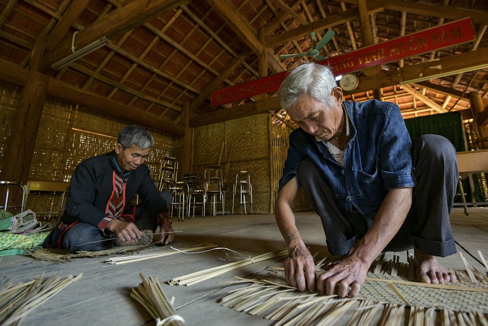 a man and a woman working on a piece of wood