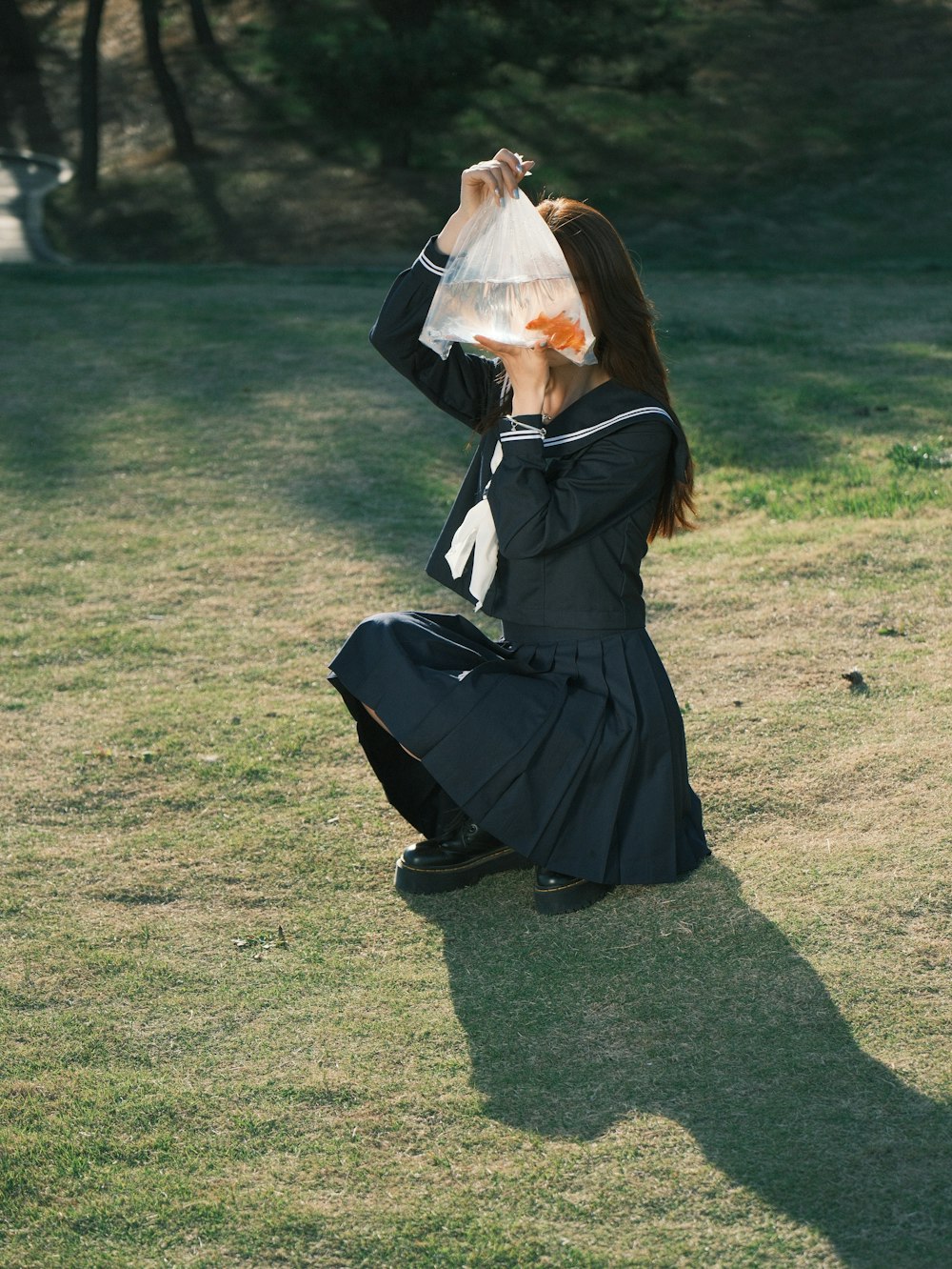 a woman sitting on the ground with a bag over her head