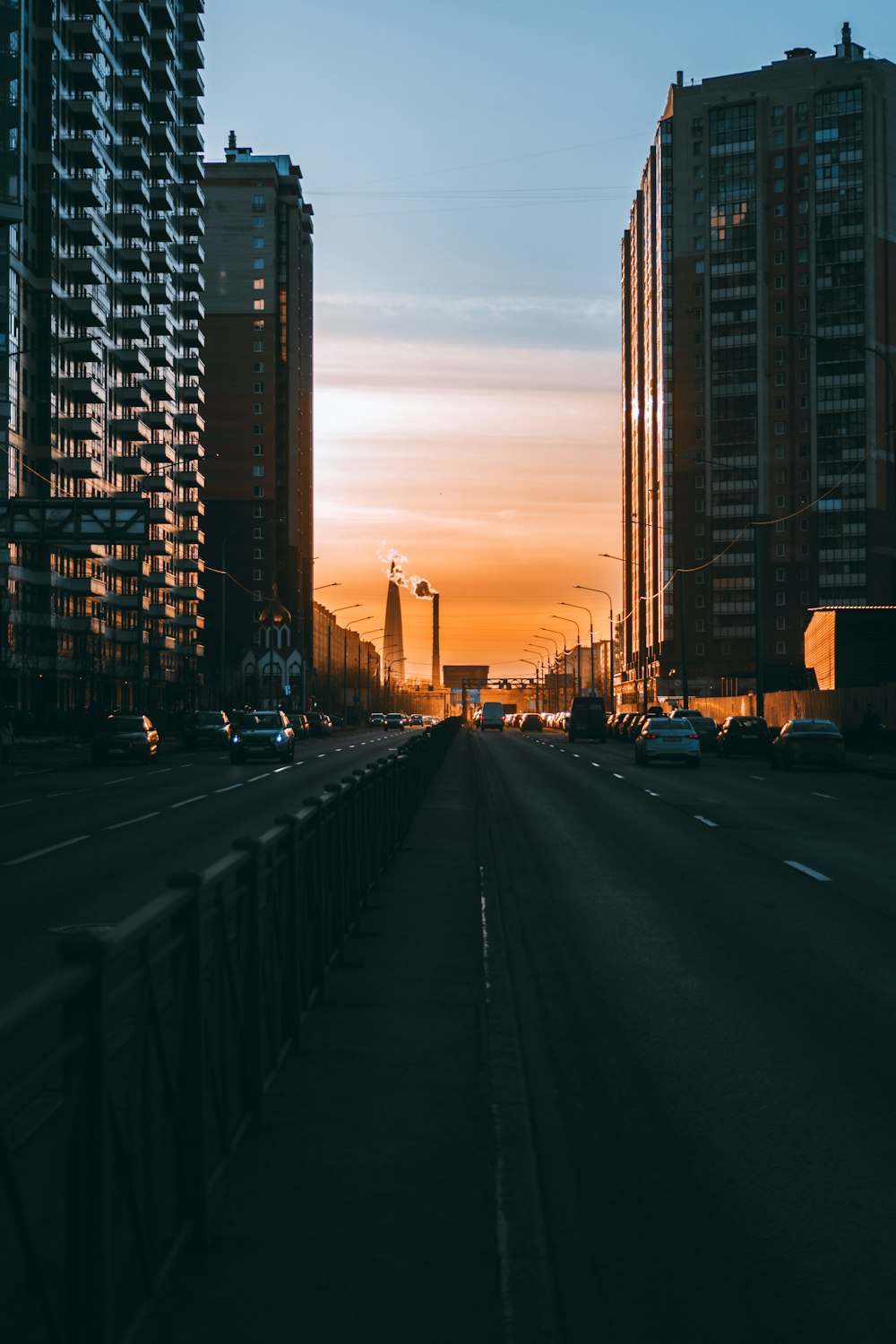 the sun is setting over a city street