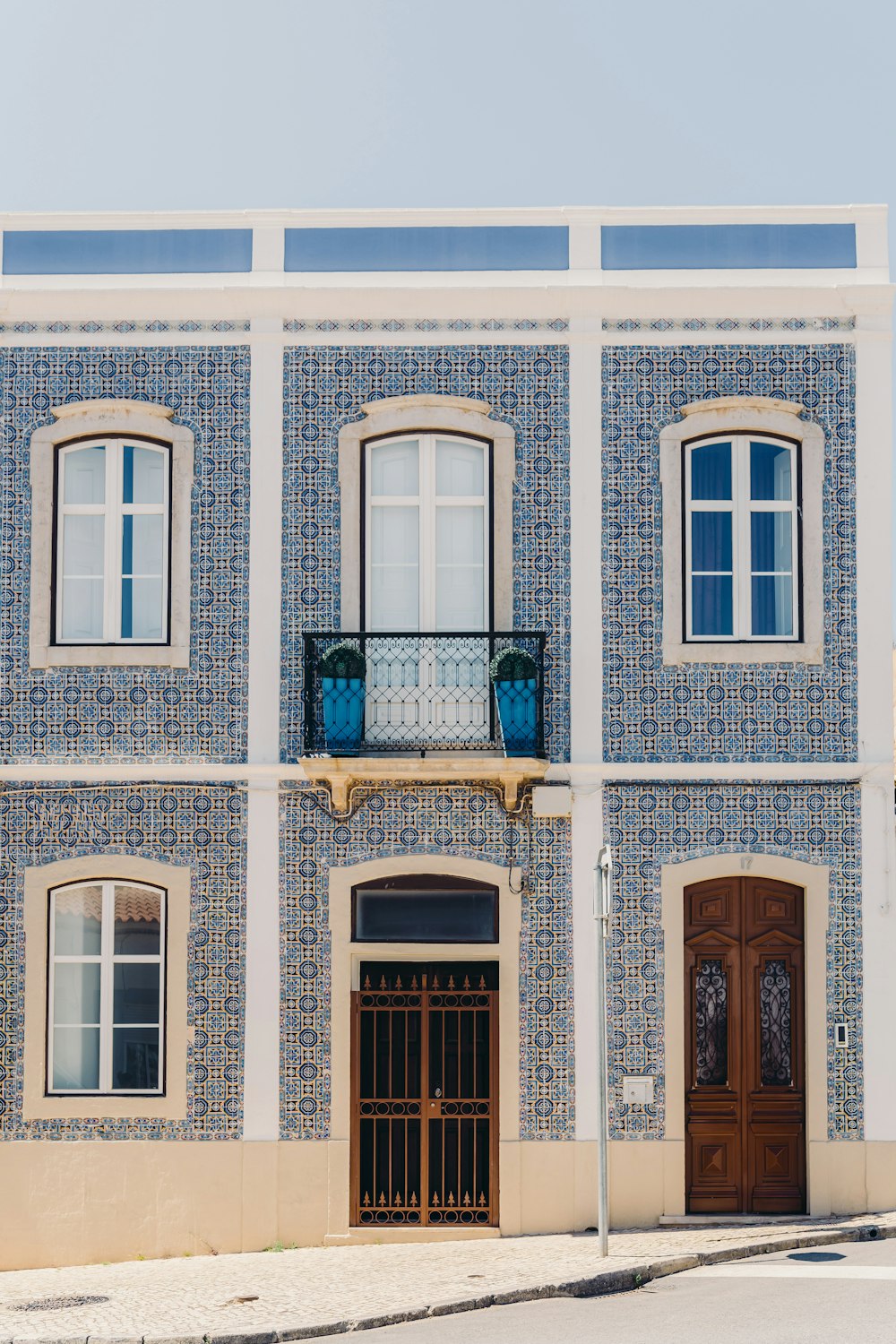 um edifício azul e branco com uma porta marrom