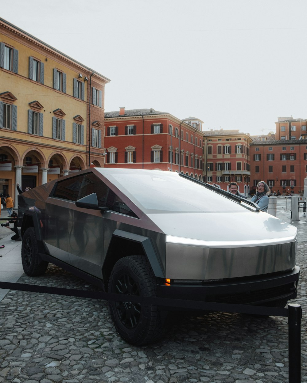 a futuristic car is parked on a cobblestone street