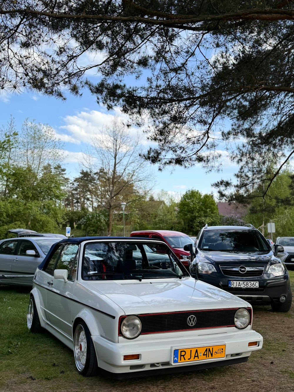 a group of cars parked next to each other on a field