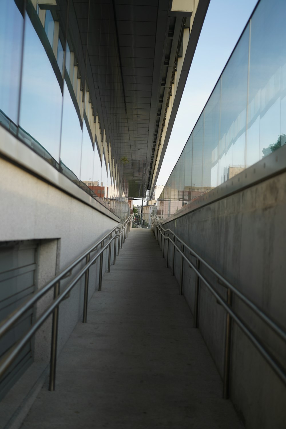 a long walkway between two buildings with railings