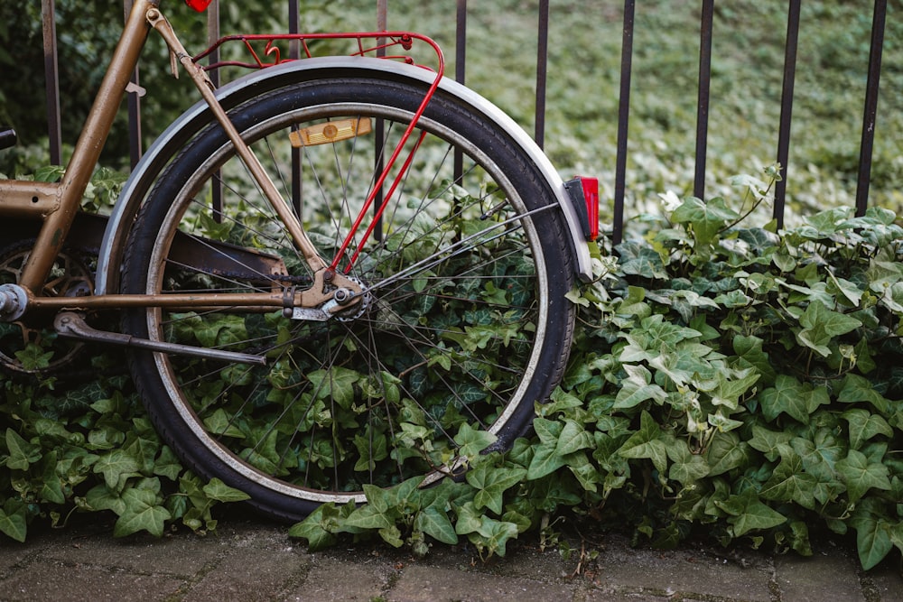 an old bicycle is leaning against a fence