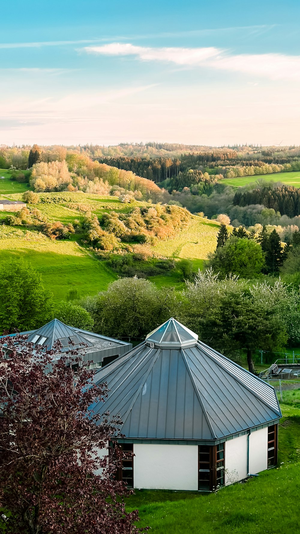 a small building in the middle of a lush green field