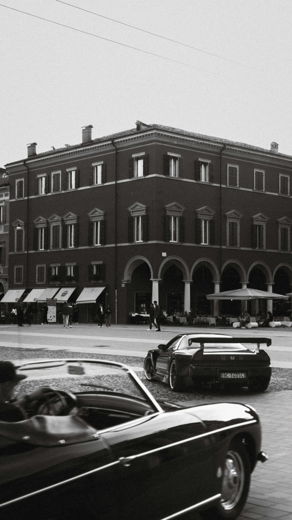 a black and white photo of a building and cars
