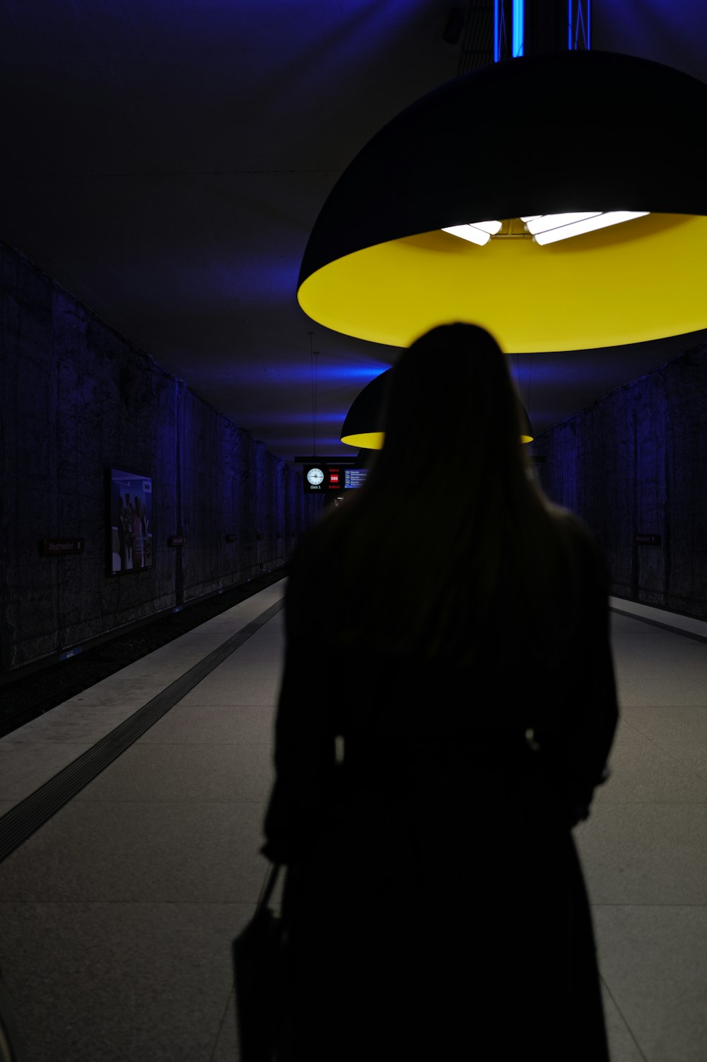 a woman is walking down a dark hallway