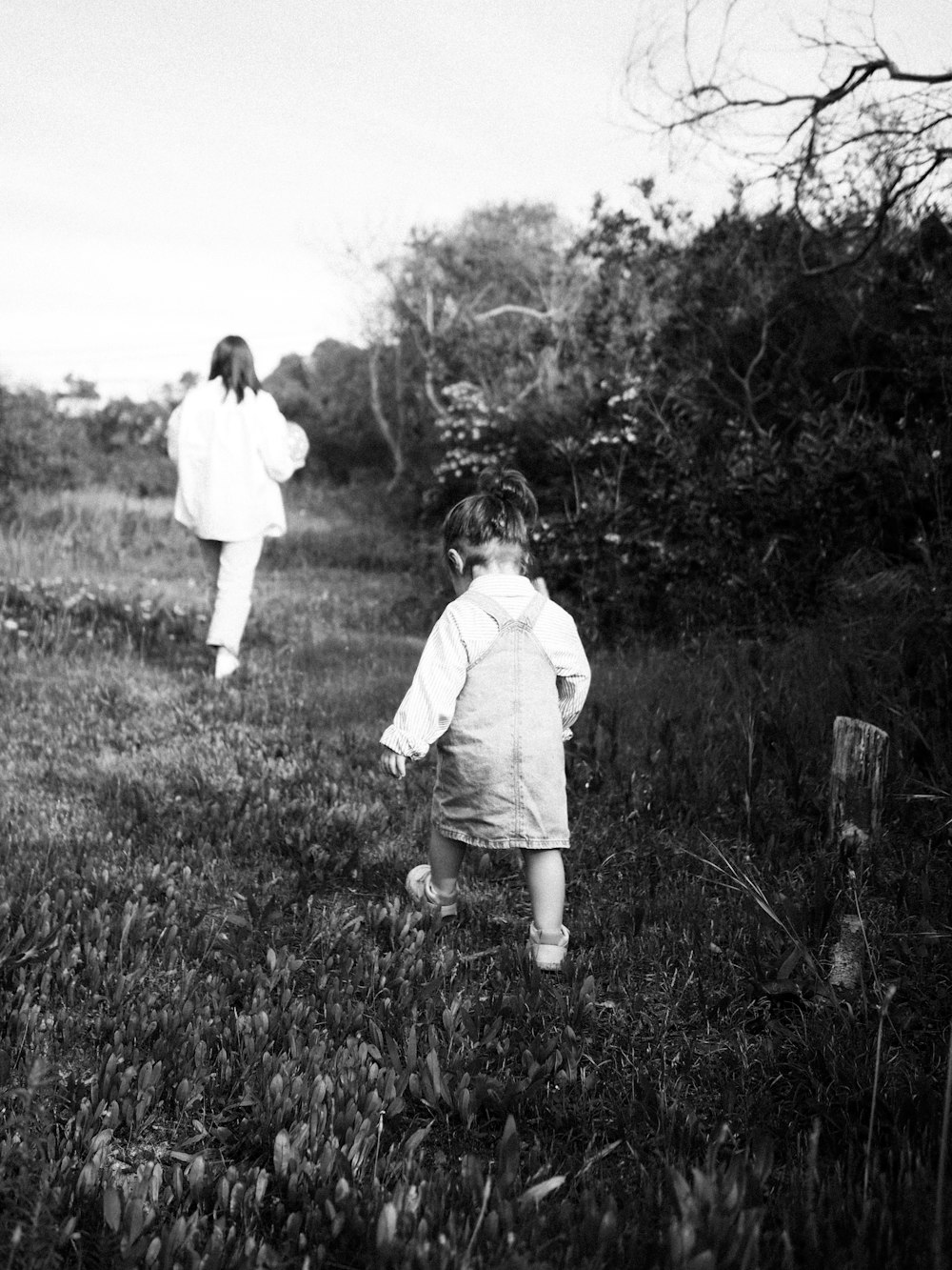 Una foto en blanco y negro de dos niños en un campo