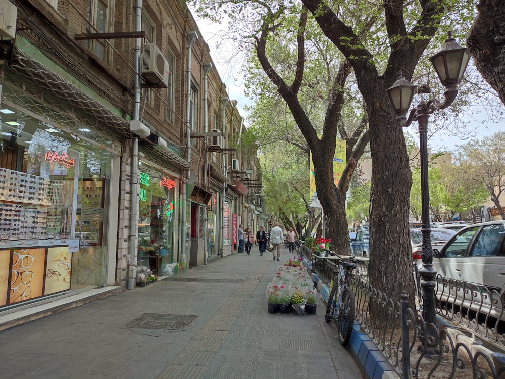 a city street lined with parked cars next to tall buildings