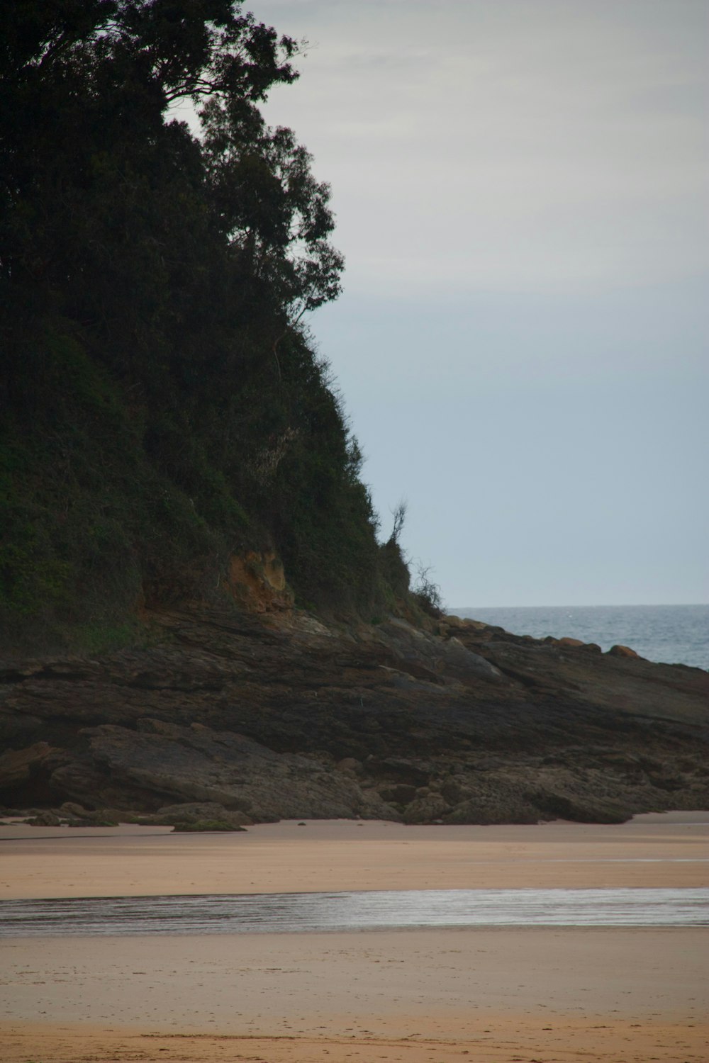 a person walking on a beach with a surfboard