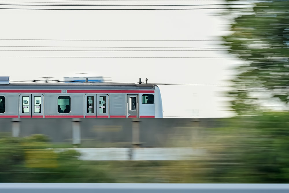 a red and white train traveling over a bridge