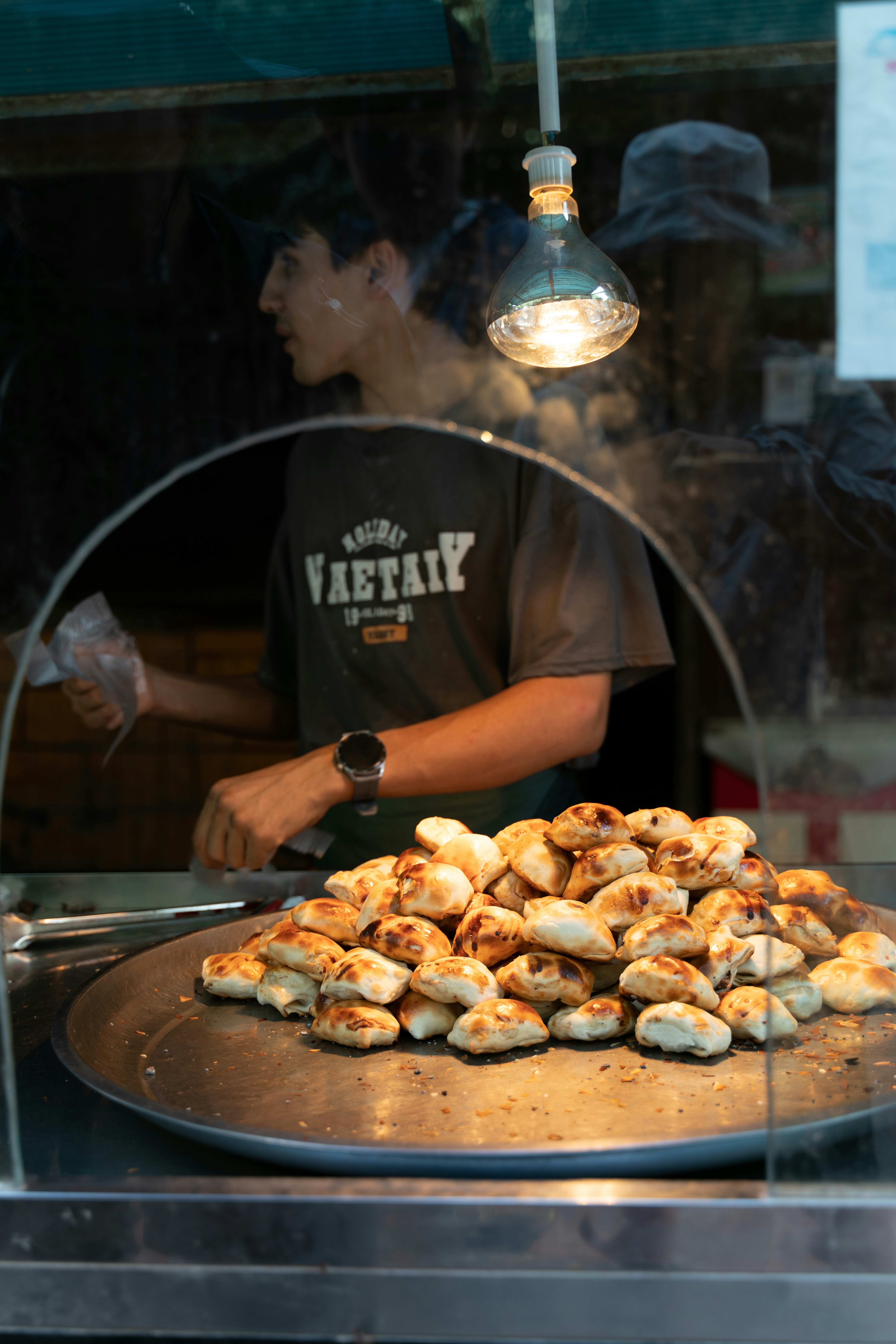 a man standing behind a counter filled with pastries
