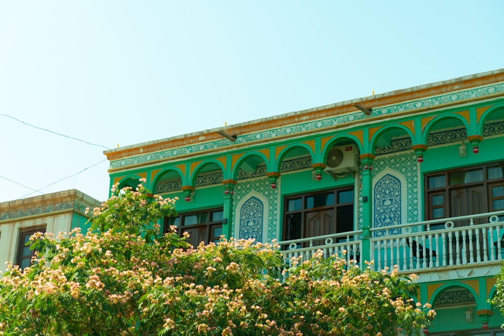 un edificio verde e giallo con balcone e balconi