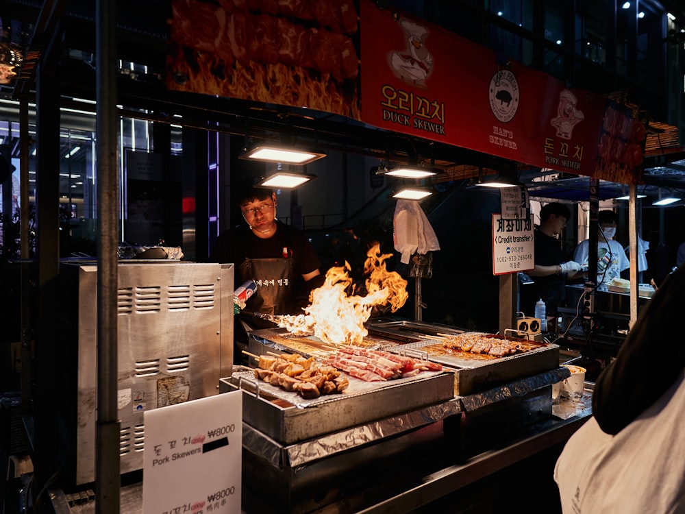 a man cooking food on a grill in a restaurant