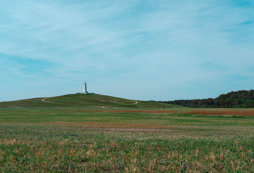 a grassy hill with a light house on top of it