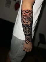 a man with a tiger and lion tattoo on his arm