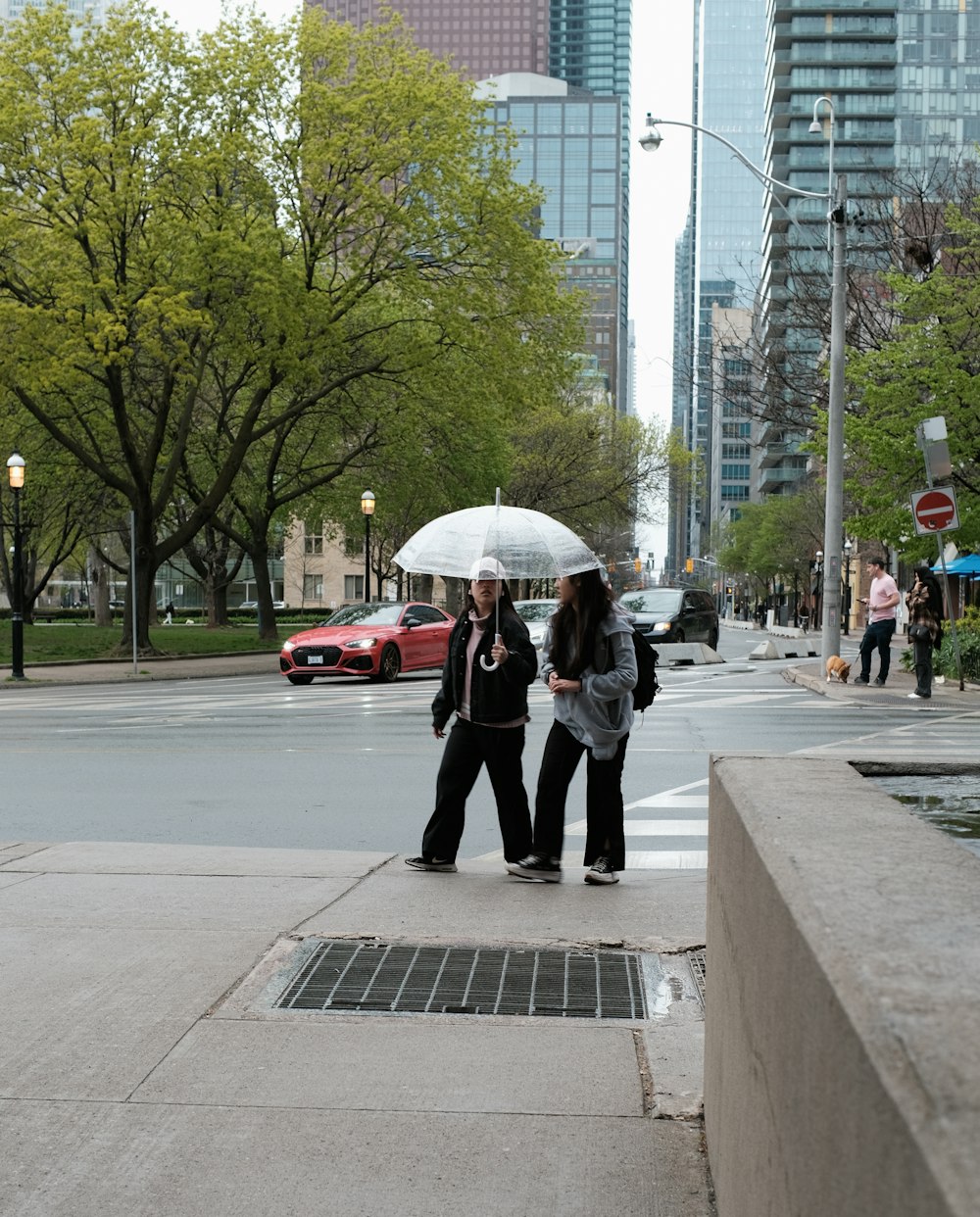 two people standing under an umbrella on a city street