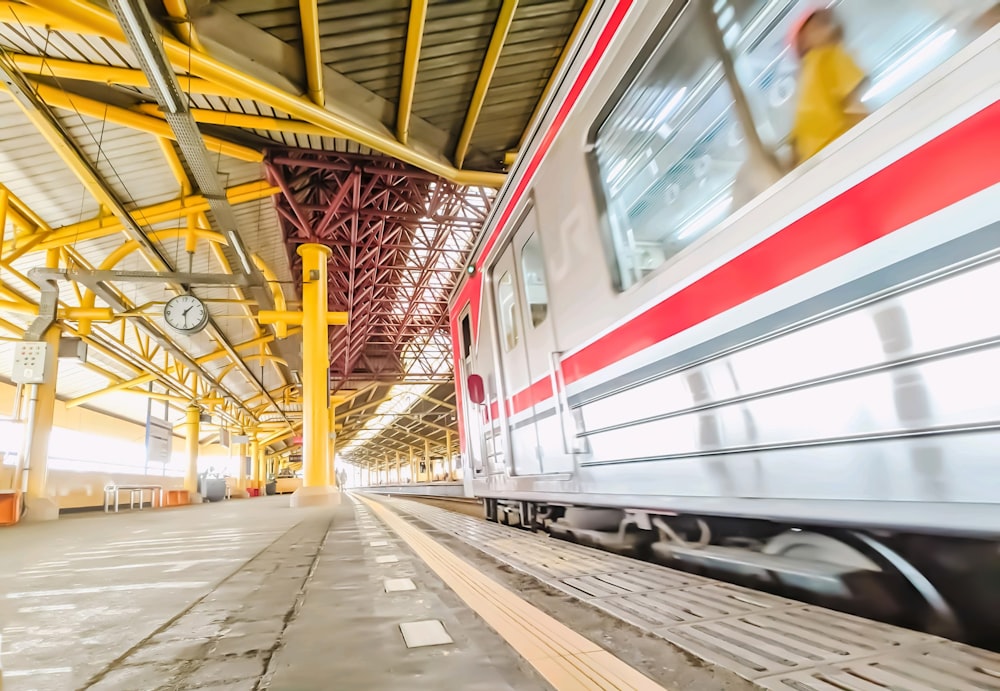 a train traveling past a train station next to a platform