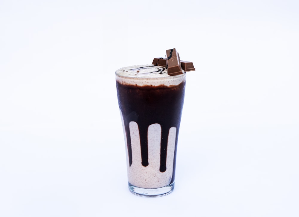 a tall glass filled with liquid and chocolate