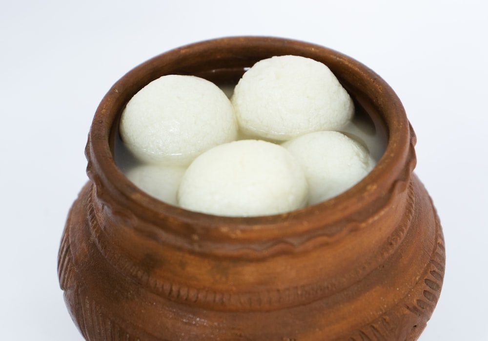 a wooden bowl filled with white balls of food
