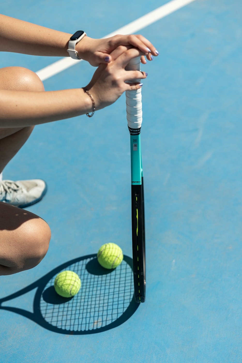 a woman kneeling down on a tennis court holding a racquet